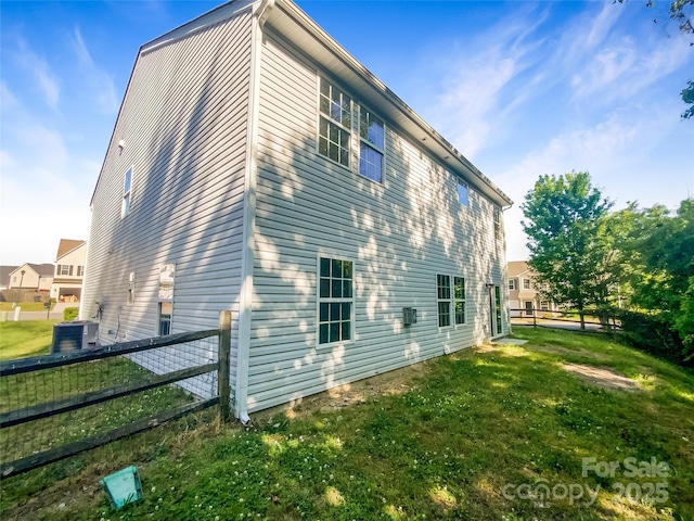 view of home's exterior with fence, a yard, and cooling unit