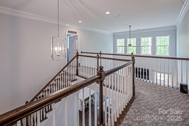 hallway featuring recessed lighting, ornamental molding, a notable chandelier, and an upstairs landing