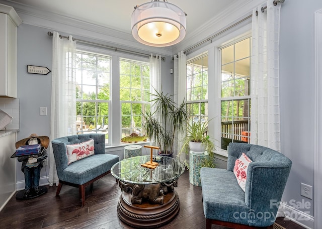 living area with baseboards, ornamental molding, and wood finished floors