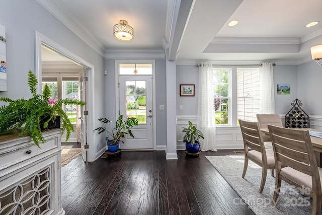 foyer featuring crown molding, wainscoting, and dark wood-type flooring