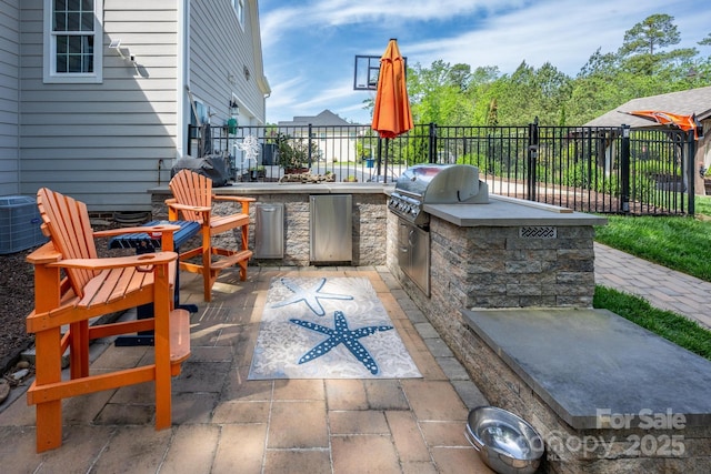 view of patio featuring central air condition unit, fence, grilling area, and an outdoor kitchen