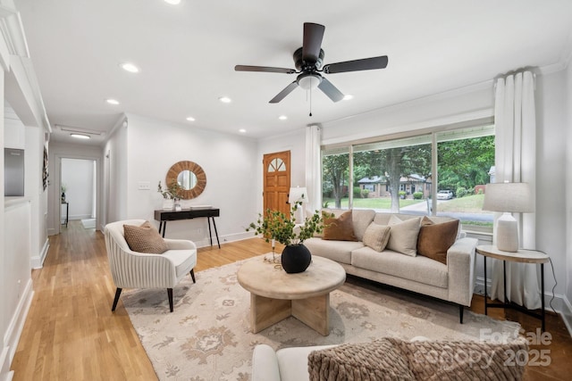 living room featuring crown molding, light wood-style floors, baseboards, ceiling fan, and recessed lighting
