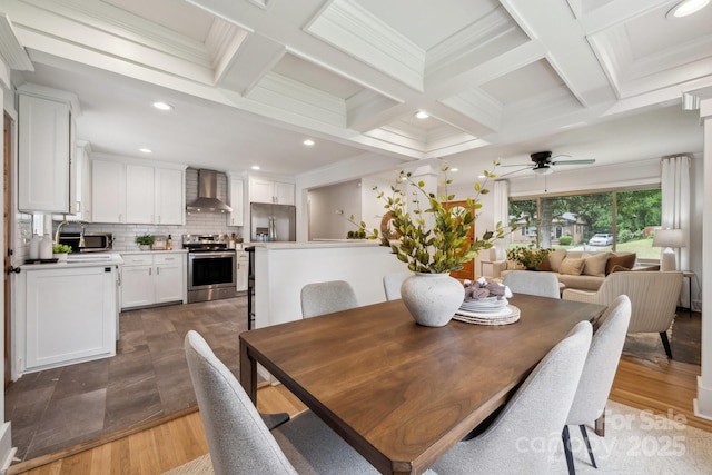 dining space with coffered ceiling, light wood finished floors, and beam ceiling