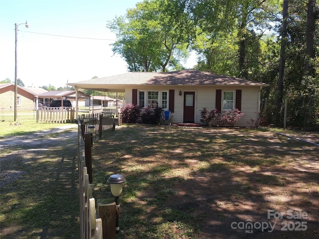 ranch-style house featuring fence, driveway, and a carport