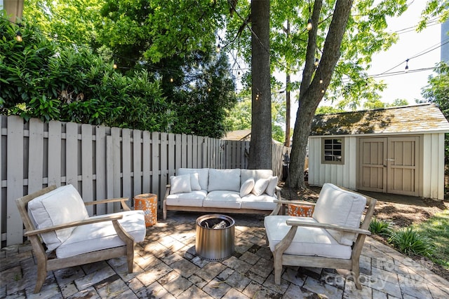 view of patio / terrace featuring a fenced backyard, a storage unit, an outdoor hangout area, and an outdoor structure