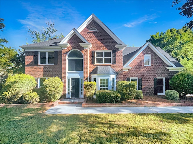 view of front of property featuring brick siding and a front lawn