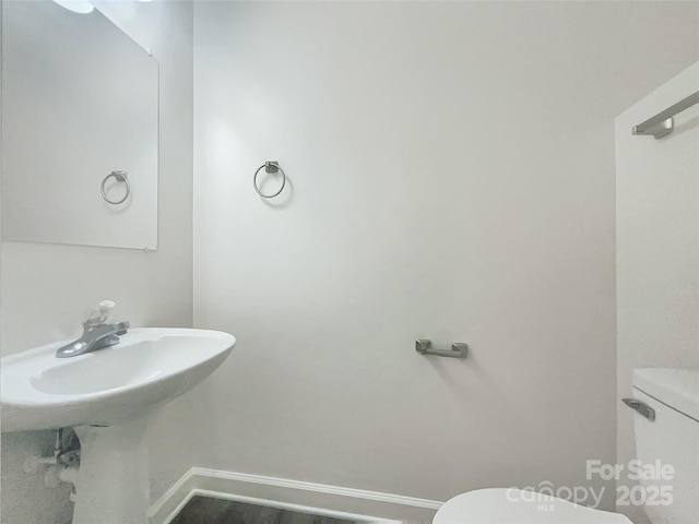 bathroom featuring baseboards and toilet