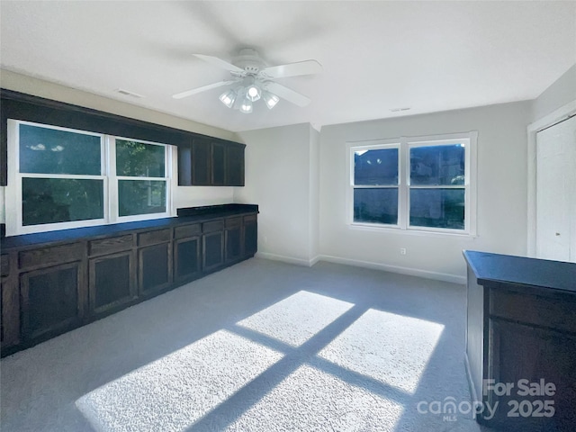 unfurnished living room featuring a ceiling fan, baseboards, visible vents, and carpet