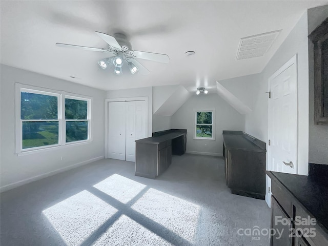 additional living space with visible vents, baseboards, ceiling fan, and light carpet