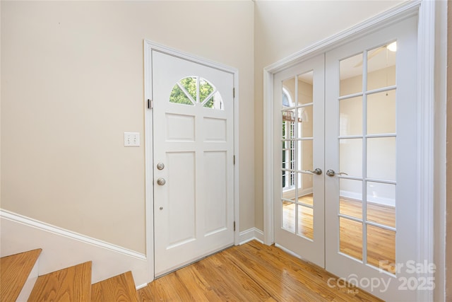 entrance foyer featuring light wood-style flooring, french doors, and baseboards