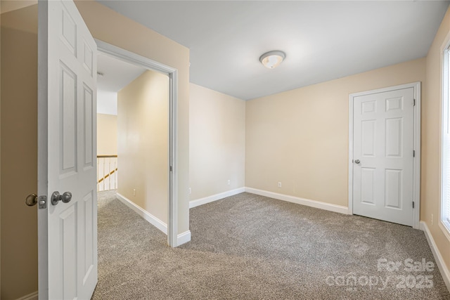 carpeted spare room featuring baseboards