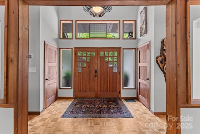 entrance foyer featuring baseboards and a high ceiling