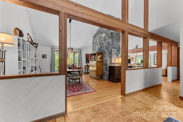 living area with baseboards, parquet flooring, and high vaulted ceiling
