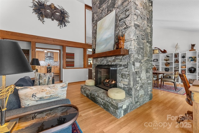 living area featuring a stone fireplace and wood finished floors