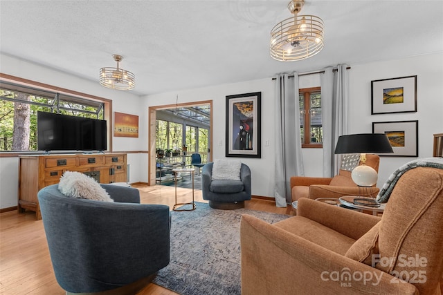 living room featuring baseboards and a notable chandelier