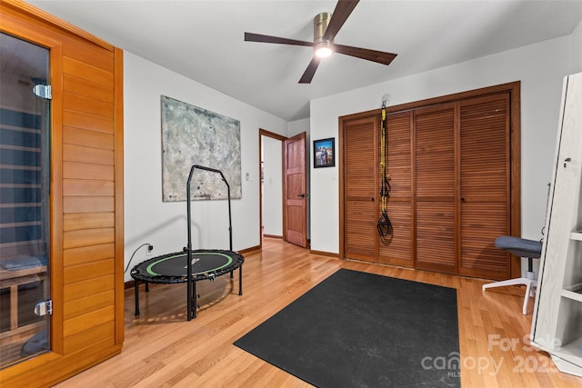 exercise room with baseboards, ceiling fan, and wood finished floors
