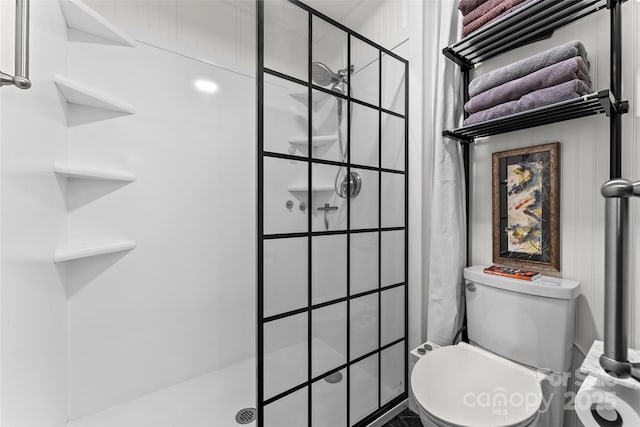bathroom with toilet and a tile shower