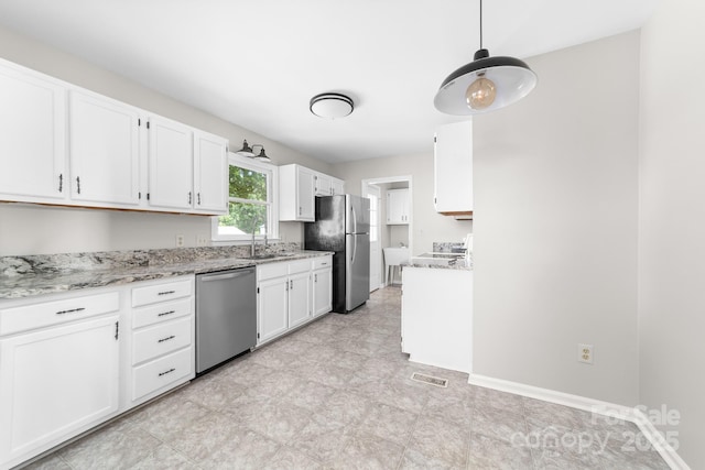 kitchen featuring visible vents, appliances with stainless steel finishes, a sink, light stone counters, and white cabinets