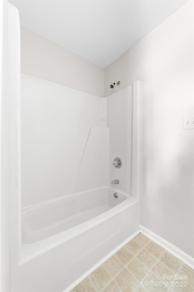 bathroom with shower / bath combination and baseboards
