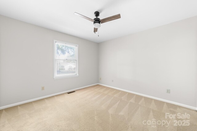unfurnished room with a ceiling fan, baseboards, visible vents, and light carpet
