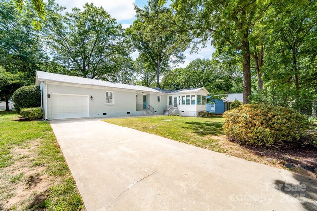 view of front of home featuring crawl space, driveway, a front yard, and a garage