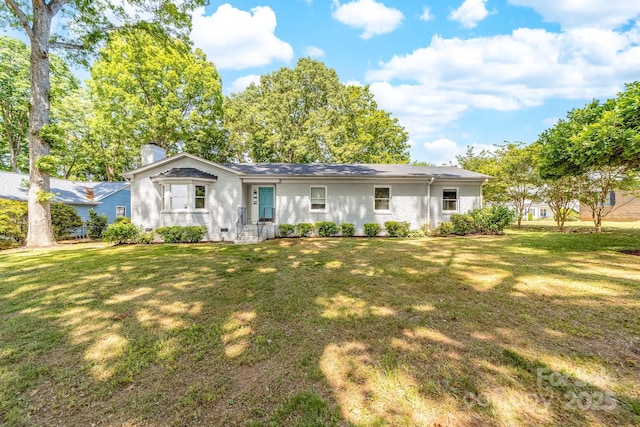 back of property with brick siding, a yard, and a chimney