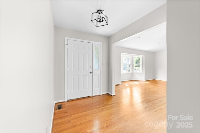 foyer with baseboards, visible vents, and light wood-style flooring