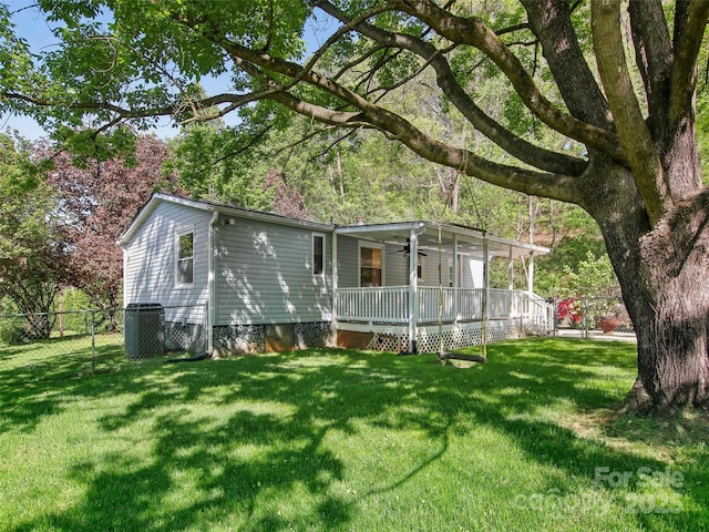 exterior space featuring a yard, ceiling fan, fence, and central AC unit