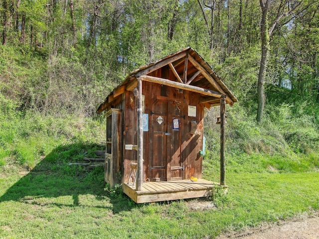 view of outbuilding featuring a view of trees and an outbuilding