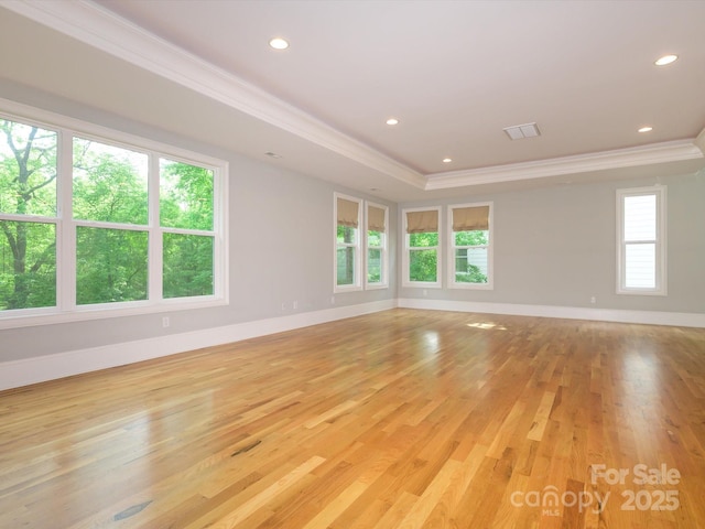 7324 Leharne Dr, Charlotte, NC 28270 - spare room featuring visible vents, baseboards, ornamental molding, a tray ceiling, and light wood-style flooring