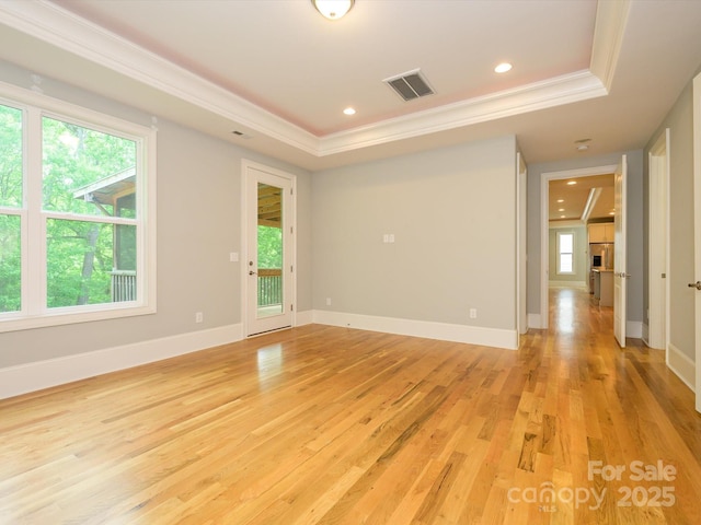 7324 Leharne Dr, Charlotte, NC 28270 - spare room featuring visible vents, crown molding, light wood-type flooring, a tray ceiling, and a wealth of natural light