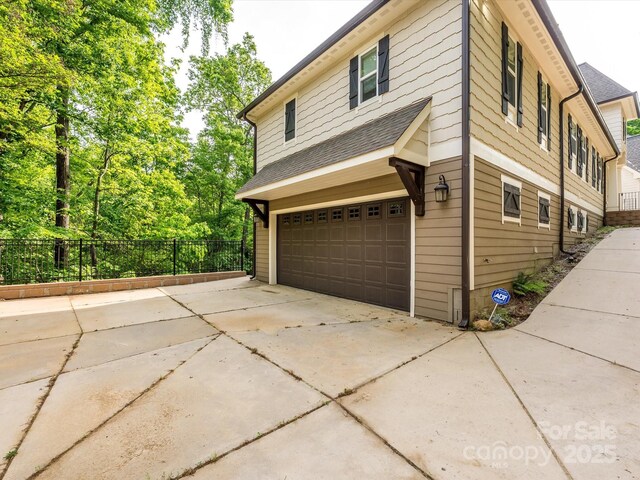 7324 Leharne Dr, Charlotte, NC 28270 - view of property exterior with a garage, roof with shingles, and fence