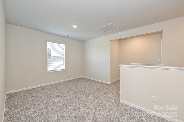 unfurnished room featuring carpet floors, baseboards, and visible vents