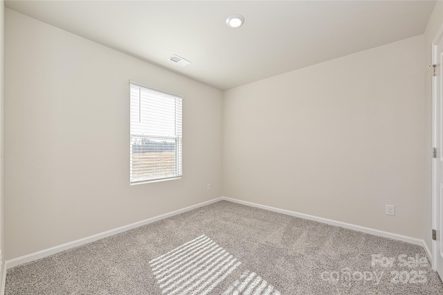 empty room with baseboards, carpet flooring, and visible vents