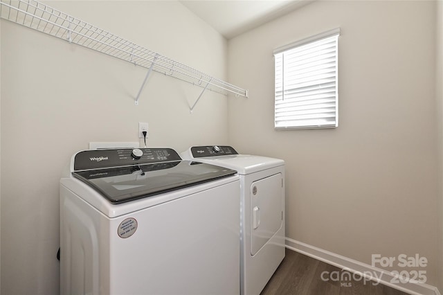 clothes washing area with baseboards, laundry area, dark wood-style flooring, and washer and dryer
