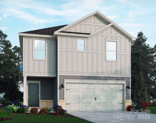 view of front of house with a garage, board and batten siding, driveway, and brick siding