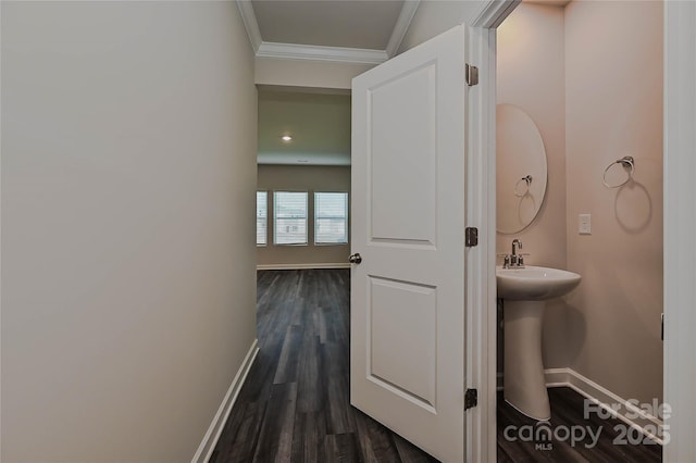 bathroom with baseboards, a sink, ornamental molding, and wood finished floors