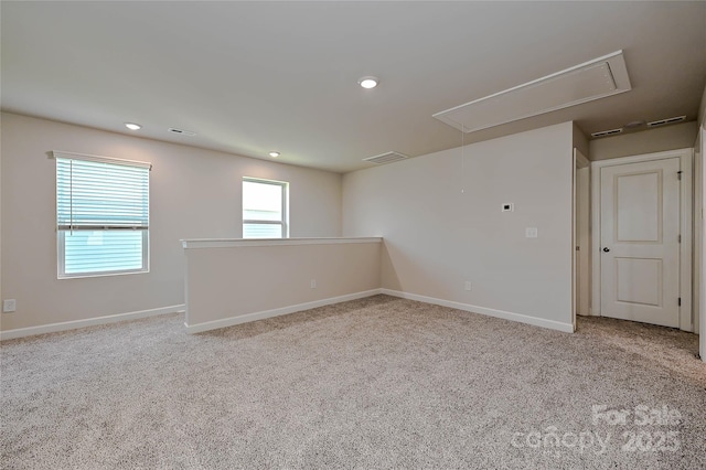 carpeted spare room with recessed lighting, baseboards, visible vents, and attic access