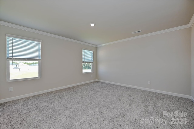 carpeted spare room featuring crown molding, baseboards, and visible vents