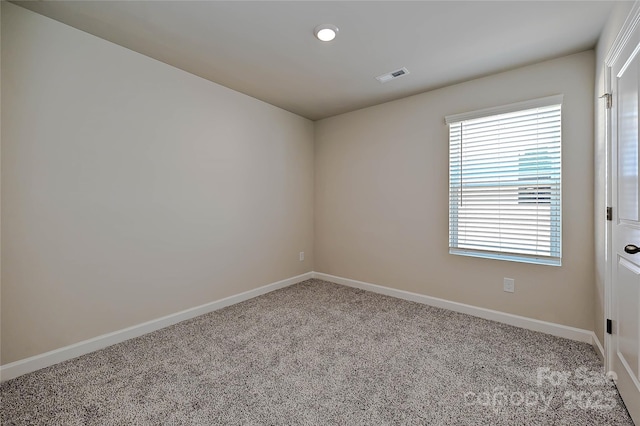 carpeted spare room with baseboards and visible vents