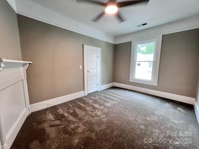 carpeted empty room with ceiling fan, baseboards, and crown molding