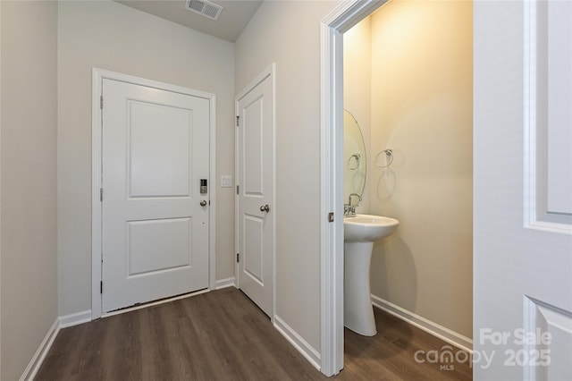bathroom with baseboards, visible vents, and wood finished floors