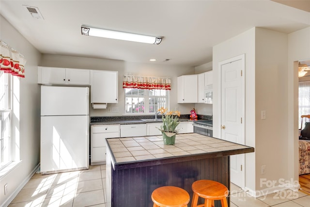 1605 Tate Rd Unit 258, Rock Hill, SC 29732 - kitchen featuring white appliances, tile counters, a sink, white cabinetry, and light tile patterned floors