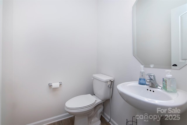 3252 Cheyney Park Dr, Charlotte, NC 28269 - half bathroom with a sink, toilet, baseboards, and wood finished floors