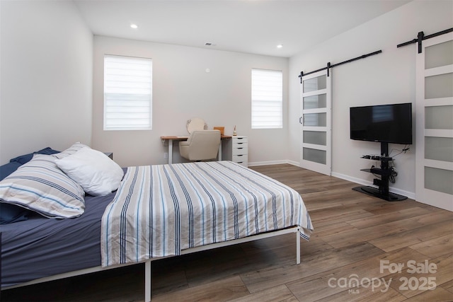 3252 Cheyney Park Dr, Charlotte, NC 28269 - bedroom featuring wood finished floors, visible vents, a barn door, and baseboards