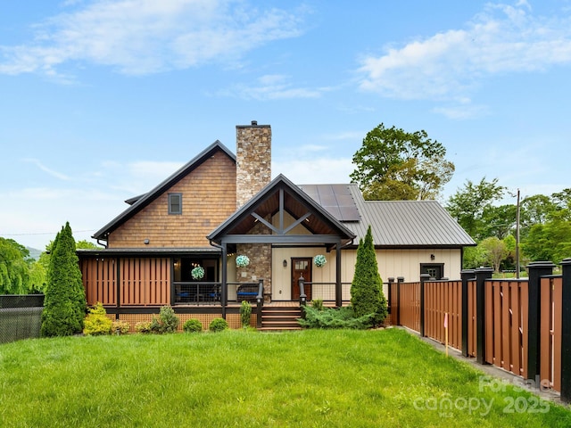 back of house featuring a chimney, solar panels, and board and batten siding