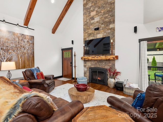 living area featuring wood finished floors, high vaulted ceiling, a fireplace, beam ceiling, and baseboards