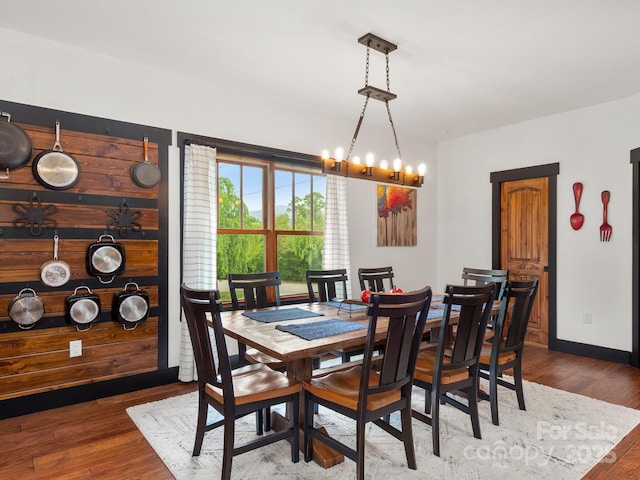 dining room with a chandelier, wood finished floors, and baseboards
