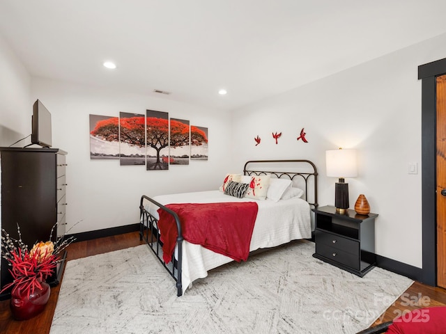 bedroom featuring wood finished floors, baseboards, and recessed lighting