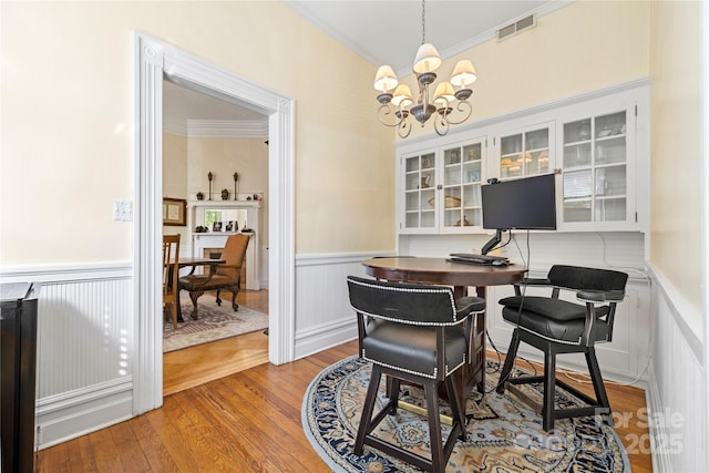 116 N Mulberry St, Statesville, NC 28677 - dining area featuring ornamental molding, a chandelier, wainscoting, wood finished floors, and a desk